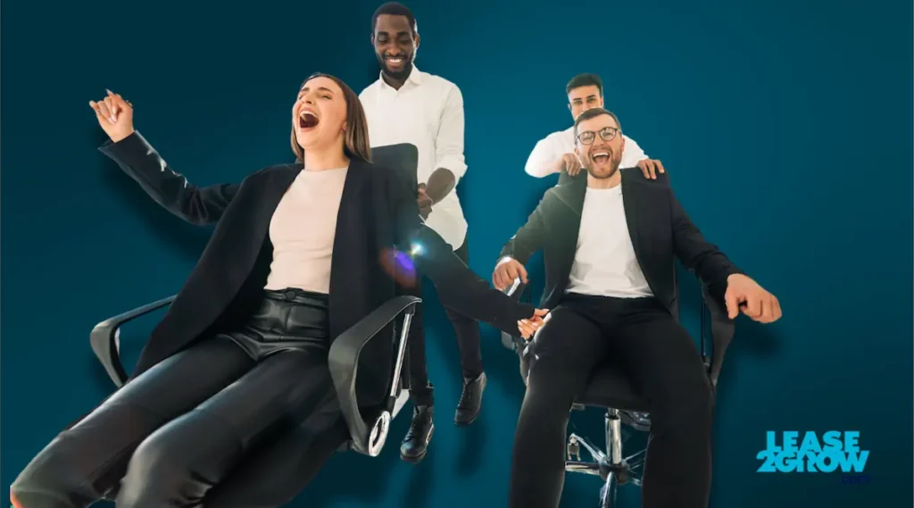 Joyful work colleagues ride chairs around the office with the lease2grow logo on ther bottom right